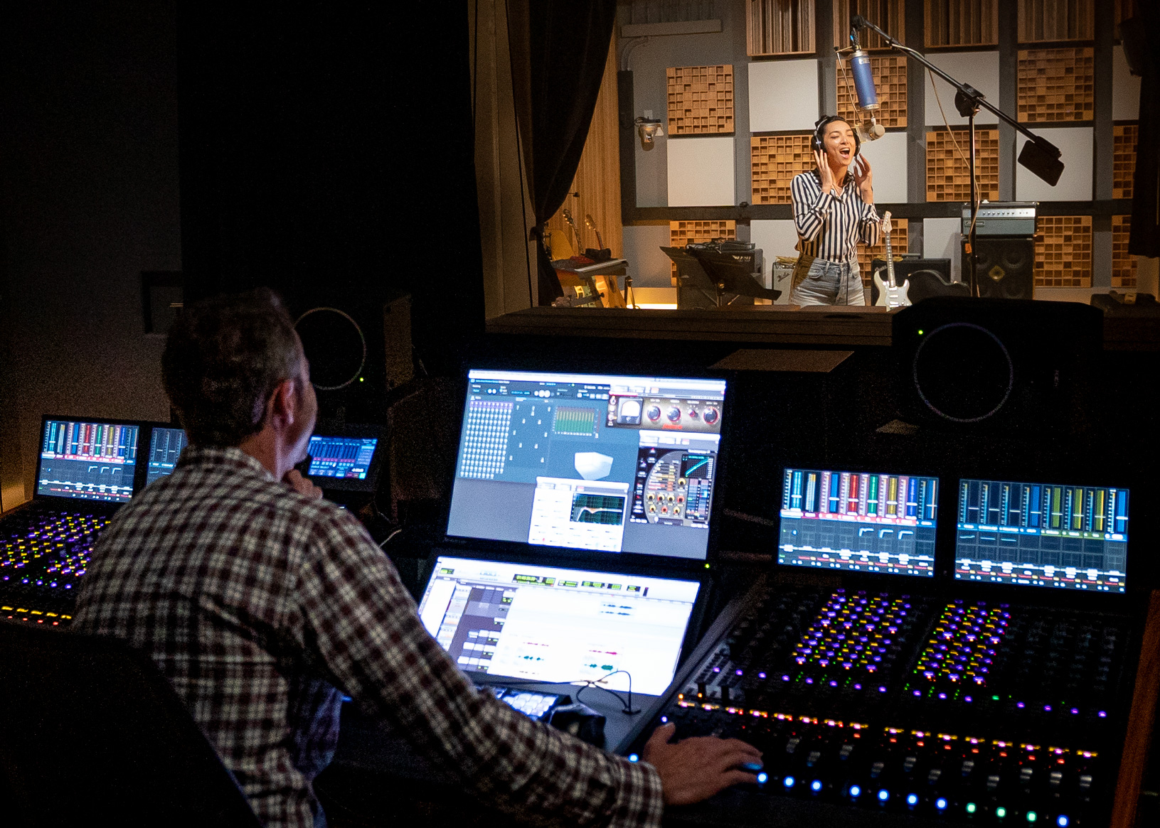 Dolby Atmos music studio with a mixing engineer and vocalist