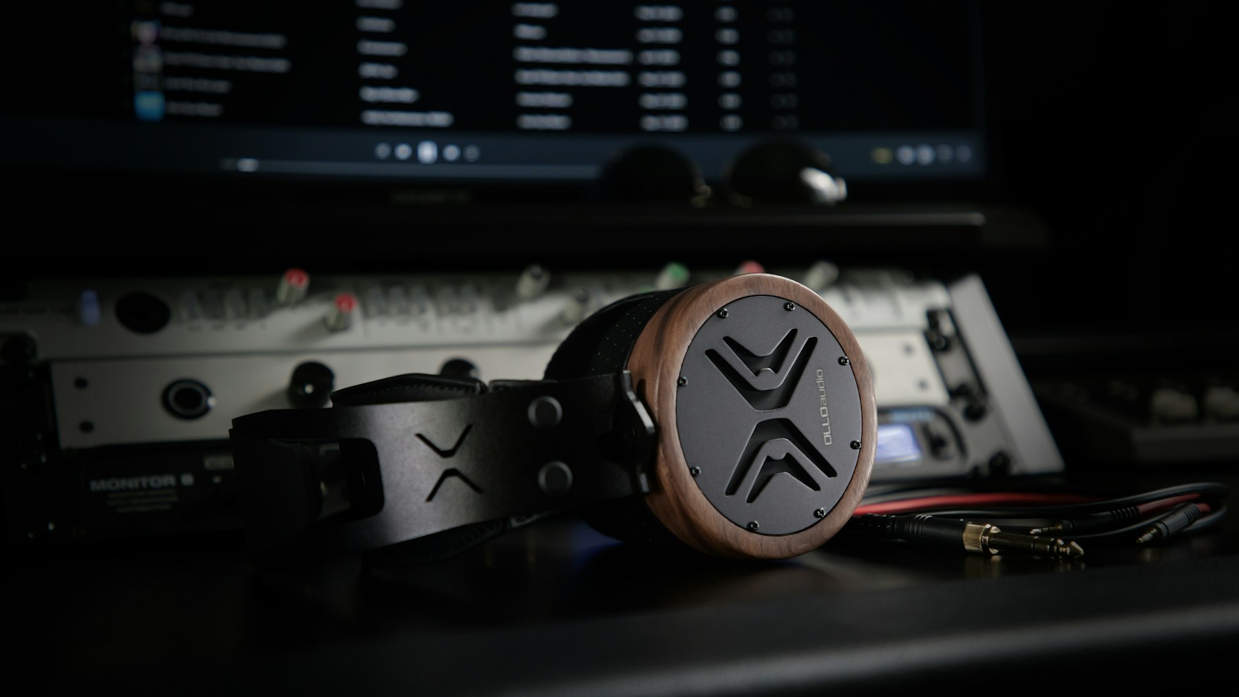 Reference headphones in front of an audio workstation used for mixing and metering