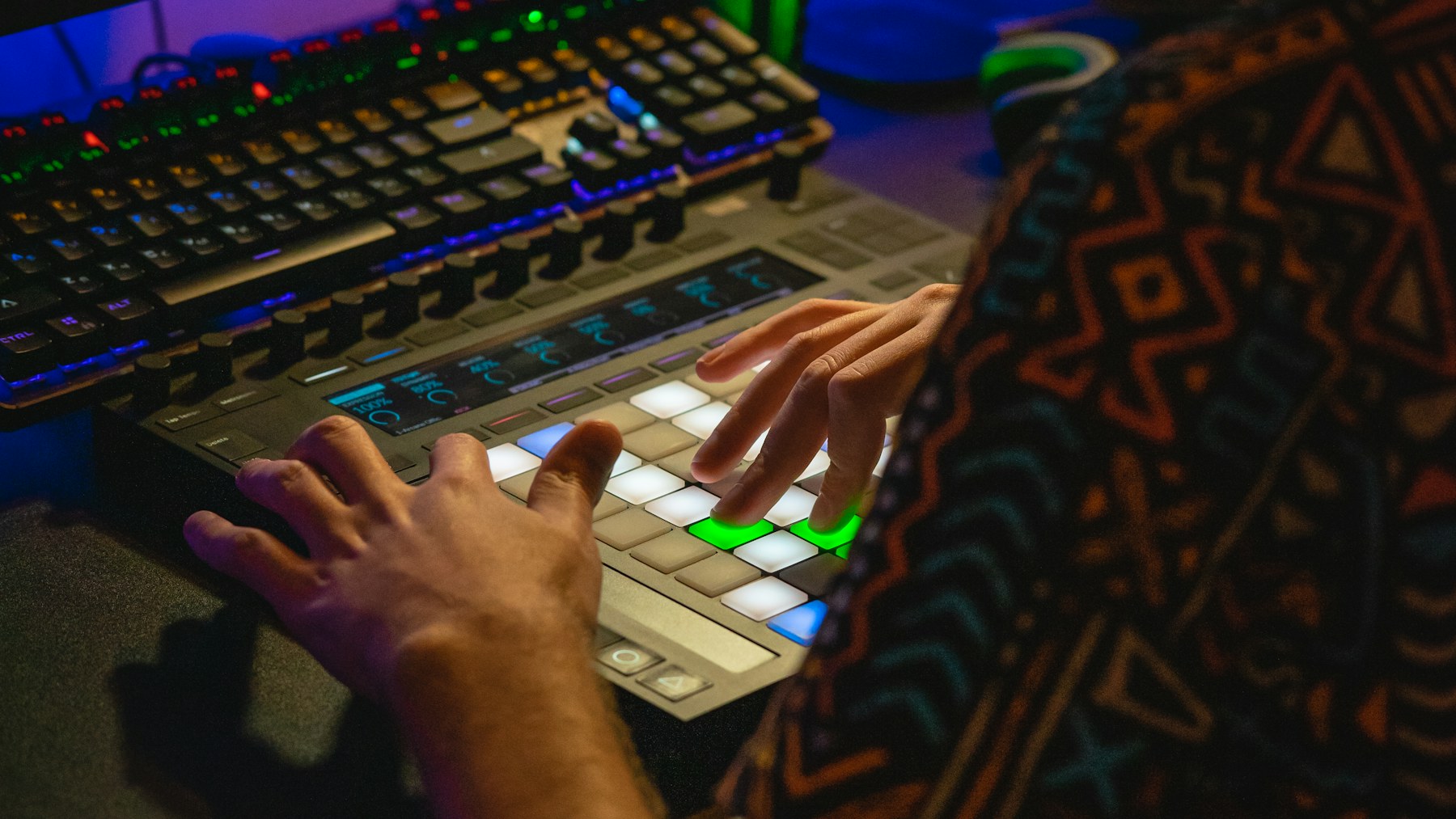 Producer using a pad-based MIDI controller in a home studio